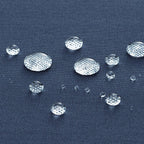 Clear, transparent oval gemstone cabochons with a textured, diamond-like surface arranged on a dark navy blue fabric background to demonstrate water repellency.