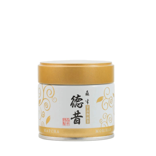 Matcha tea canister with gold lid on a white background