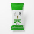 Green package of matcha powder on a white background