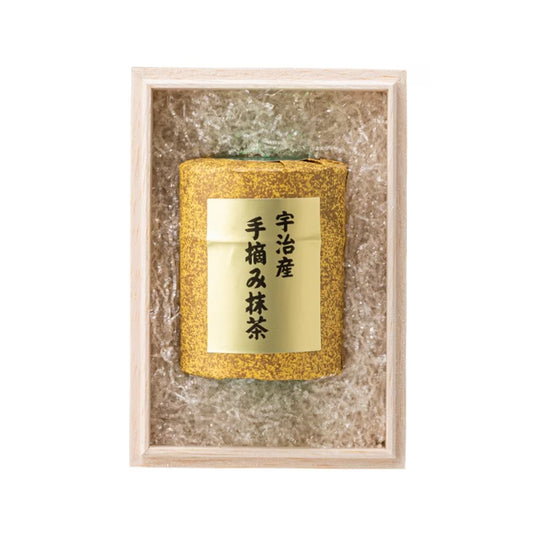 Gold cylindrical product with a label in a decorative box on a white background